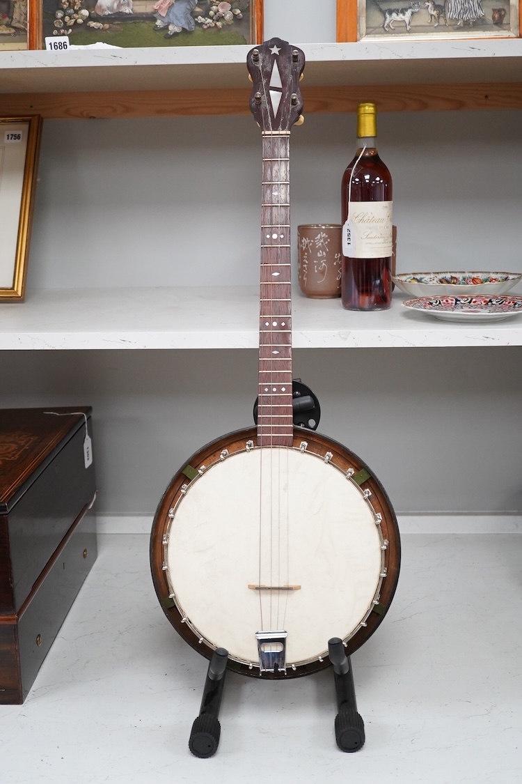 A cased Vega 4-string tenor banjo stamped M. Roccia, steel body with veneered back, the case embossed with; Ronald Quilter, 10, Cadogan Lane, London S.W.1., overall length 82cm